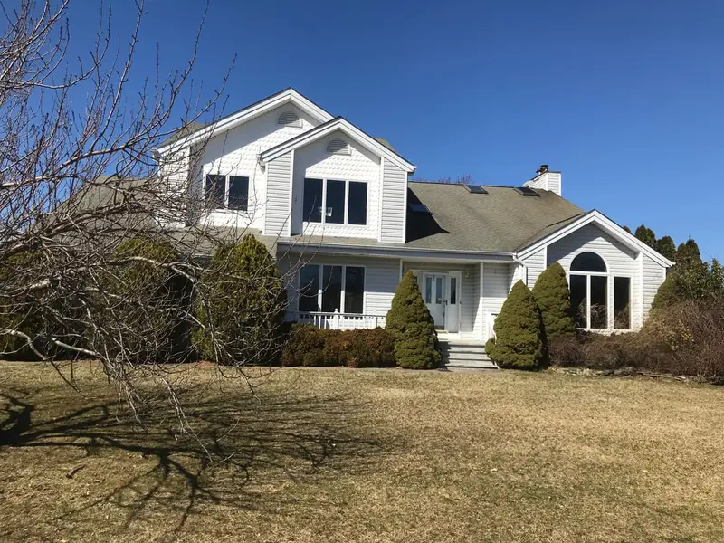 Two story colonial with arched windows and winter lawn, Riverhead, NY